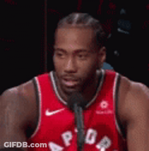 A Basketball Player Is Talking Into A Microphone . GIF
