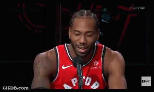 A Basketball Player Is Talking Into A Microphone While Wearing A Red Raptors Jersey . GIF