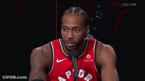 A Basketball Player Is Talking Into A Microphone While Wearing A Red Raptors Jersey . GIF
