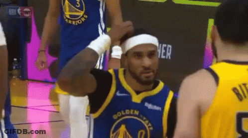 A Basketball Player Is Wearing A Headband And Talking To Another Player On The Court . GIF