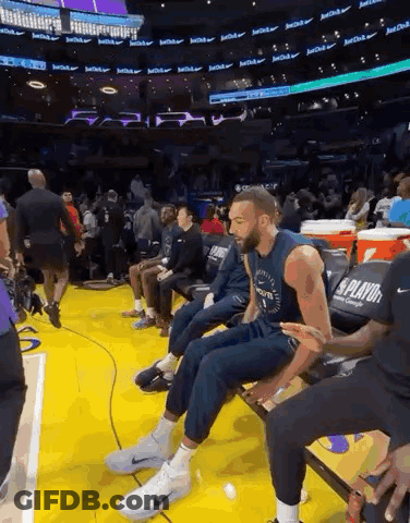 A Basketball Player Sits On A Bench During A Game GIF