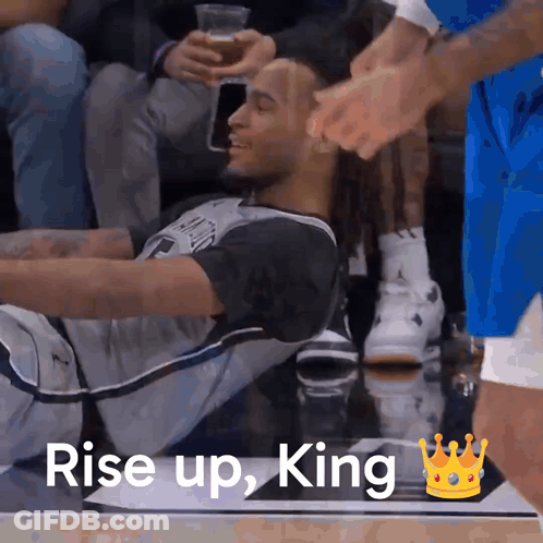 A Basketball Player Sits On The Floor With The Words Rise Up King Written Above Him GIF