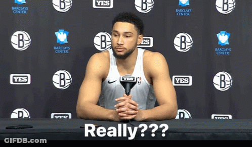 A Basketball Player Sitting At A Table With A Microphone In Front Of A Wall That Says Yes GIF
