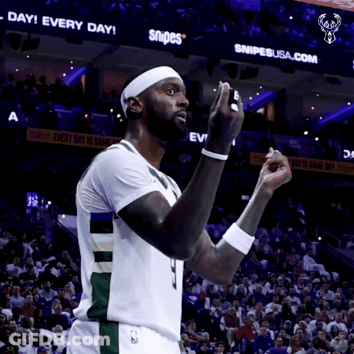 A Basketball Player Stands In Front Of A Snipes Sign GIF