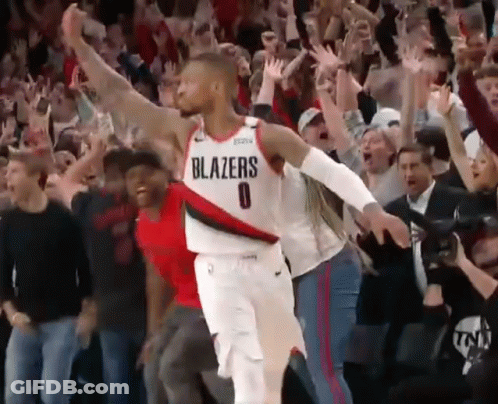 A Basketball Player Wearing A Blazers Jersey Stands In Front Of A Crowd Of People GIF