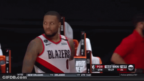 A Basketball Player Wearing A Blazers Jersey Stands On The Court GIF