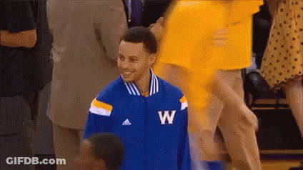 A Basketball Player Wearing A Blue And Yellow Jacket With The Letter W On It Is Smiling . GIF