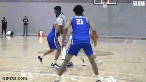 A Basketball Player Wearing A Blue Jersey With The Number 21 On It Is Dribbling The Ball . GIF
