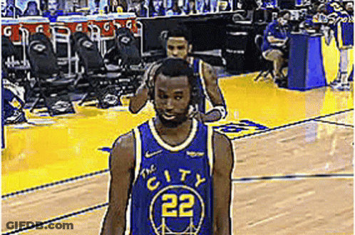 A Basketball Player Wearing A Blue Jersey With The Number 22 On It Is Walking On The Court . GIF