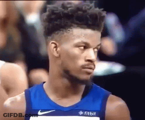 A Basketball Player Wearing A Blue Nike Jersey Is Looking At Something . GIF