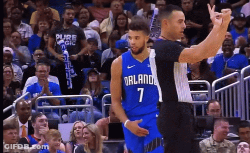 A Basketball Player Wearing A Blue Orlando Jersey Stands Next To A Referee GIF