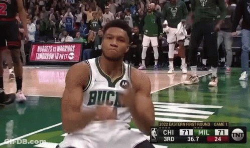 A Basketball Player Wearing A Buck Jersey Is Kneeling Down On The Court GIF
