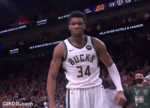 A Basketball Player Wearing A Bucks 34 Jersey Stands In Front Of A Crowd GIF