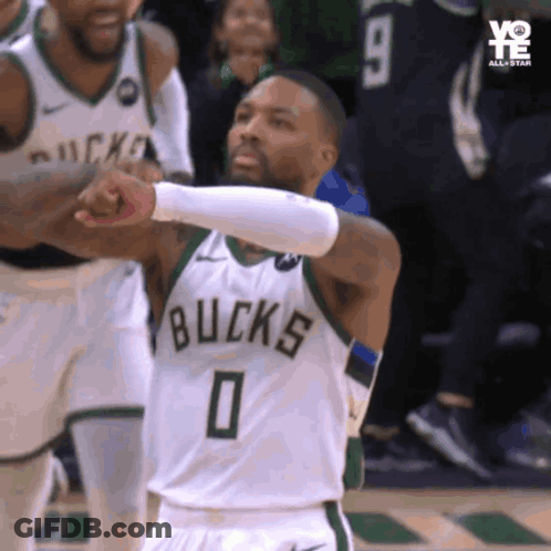 A Basketball Player Wearing A Bucks Jersey Giving A Fist Bump GIF