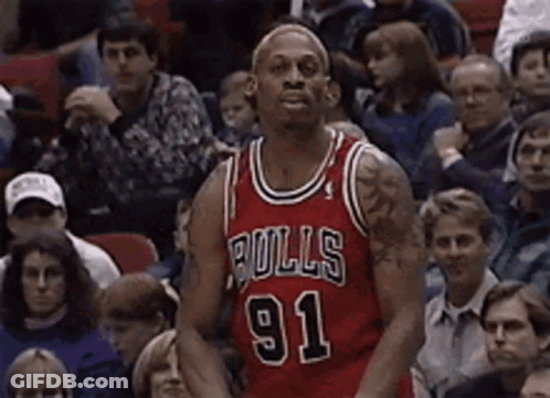 A Basketball Player Wearing A Bulls 91 Jersey Is Standing In Front Of A Crowd GIF