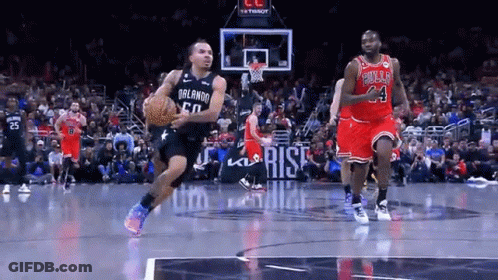 A Basketball Player Wearing A Bulls Jersey Is Dribbling The Ball GIF