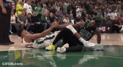 A Basketball Player Wearing A Celtics Jersey Is Laying On The Court GIF