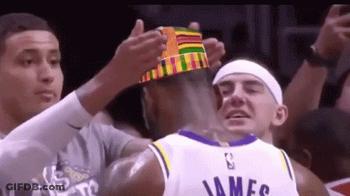 A Basketball Player Wearing A Crown Is Being Congratulated By His Teammates . GIF