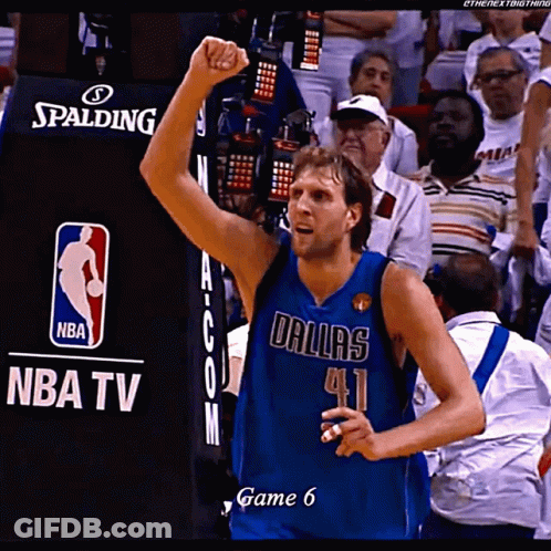 A Basketball Player Wearing A Dallas Jersey Holds Up His Fist In The Air GIF