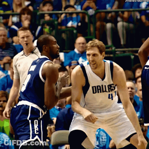 A Basketball Player Wearing A Dallas Jersey Talks To Another Player On The Court GIF