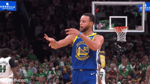 A Basketball Player Wearing A Golden State Warriors Jersey Is Standing In Front Of A Crowd GIF