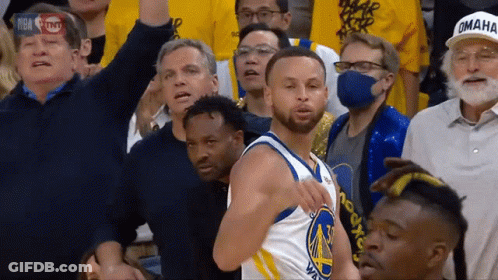 A Basketball Player Wearing A Golden State Warriors Jersey Stands In Front Of A Crowd GIF