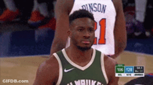 A Basketball Player Wearing A Green Jersey Is Standing On A Court . GIF