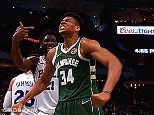 A Basketball Player Wearing A Green Milwaukee Jersey Celebrates GIF
