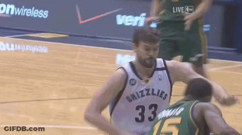 A Basketball Player Wearing A Grizzlies Jersey Is Being Fouled By Another Player GIF