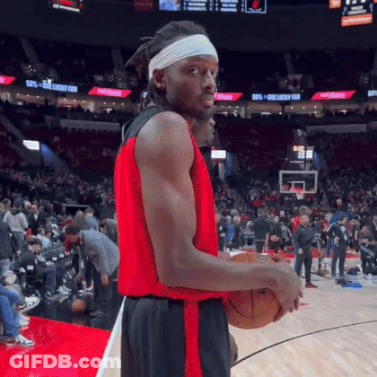 A Basketball Player Wearing A Headband Is Holding A Basketball On A Basketball Court . GIF