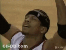 A Basketball Player Wearing A Headband Is Raising His Arms In The Air . GIF