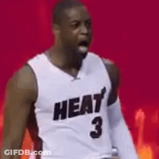A Basketball Player Wearing A Heat Jersey Is Standing In Front Of A Red Background . GIF