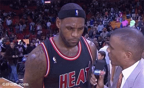 A Basketball Player Wearing A Heat Jersey Talks To A Reporter GIF