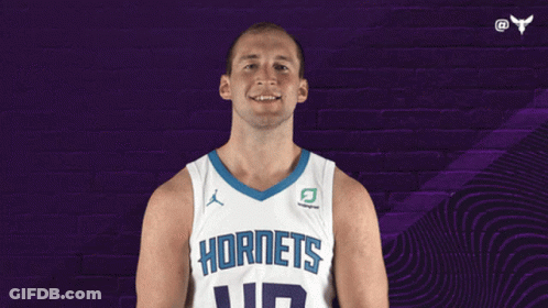A Basketball Player Wearing A Hornets Jersey Is Smiling GIF