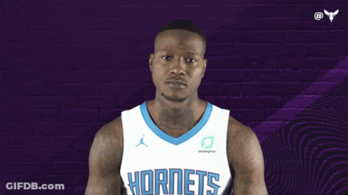 A Basketball Player Wearing A Hornets Jersey Points Up GIF