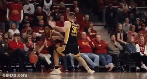 A Basketball Player Wearing A Jersey With The Number 30 On It Is Dribbling A Basketball In Front Of A Crowd Of People . GIF