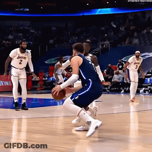 A Basketball Player Wearing A Lakers Jersey Is Dribbling The Ball GIF