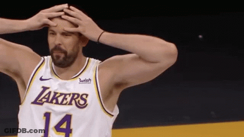 A Basketball Player Wearing A Lakers Jersey Is Holding His Head In His Hands . GIF