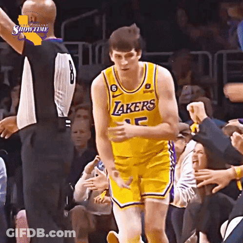 A Basketball Player Wearing A Lakers Jersey Is Standing In Front Of A Crowd GIF