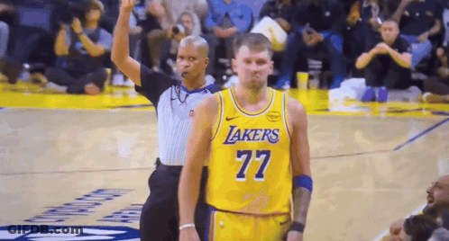 A Basketball Player Wearing A Lakers Jersey Is Standing Next To A Referee GIF