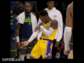A Basketball Player Wearing A Lakers Jersey Is Standing On The Court With His Arms Crossed GIF