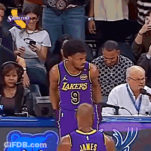 A Basketball Player Wearing A Lakers Jersey Stands In Front Of A Crowd GIF