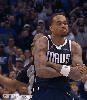 A Basketball Player Wearing A Maus Jersey Stands With His Arms Crossed GIF