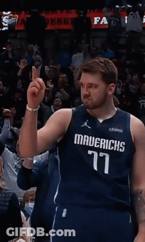A Basketball Player Wearing A Mavericks Jersey Points To The Crowd GIF