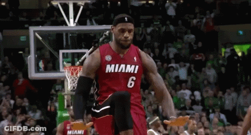 A Basketball Player Wearing A Miami Jersey Is Jumping In The Air During A Game . GIF