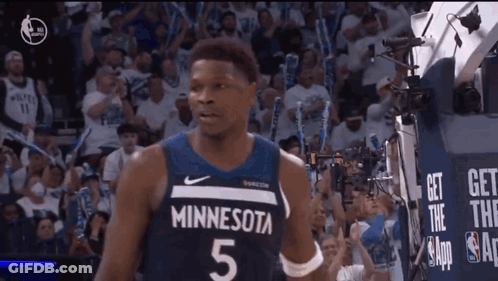 A Basketball Player Wearing A Minnesota Jersey Is Standing In Front Of A Crowd GIF