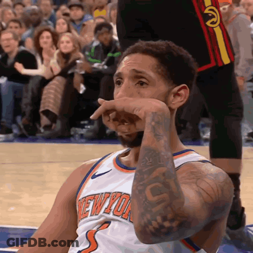 A Basketball Player Wearing A New York Jersey Wipes His Face GIF