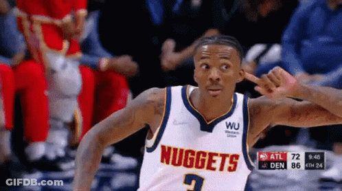 A Basketball Player Wearing A Nuggets Jersey Is Pointing GIF