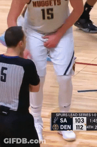 A Basketball Player Wearing A Nuggets Jersey Is Talking To A Referee GIF