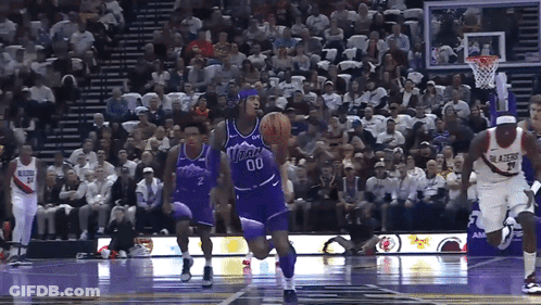 A Basketball Player Wearing A Number 00 Jersey Dribbles The Ball GIF